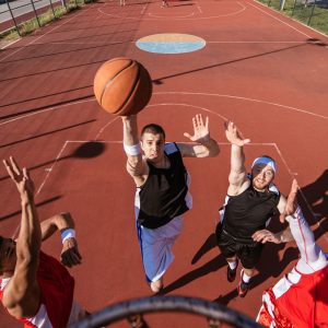 A young basketball player scoring a slam dunk.